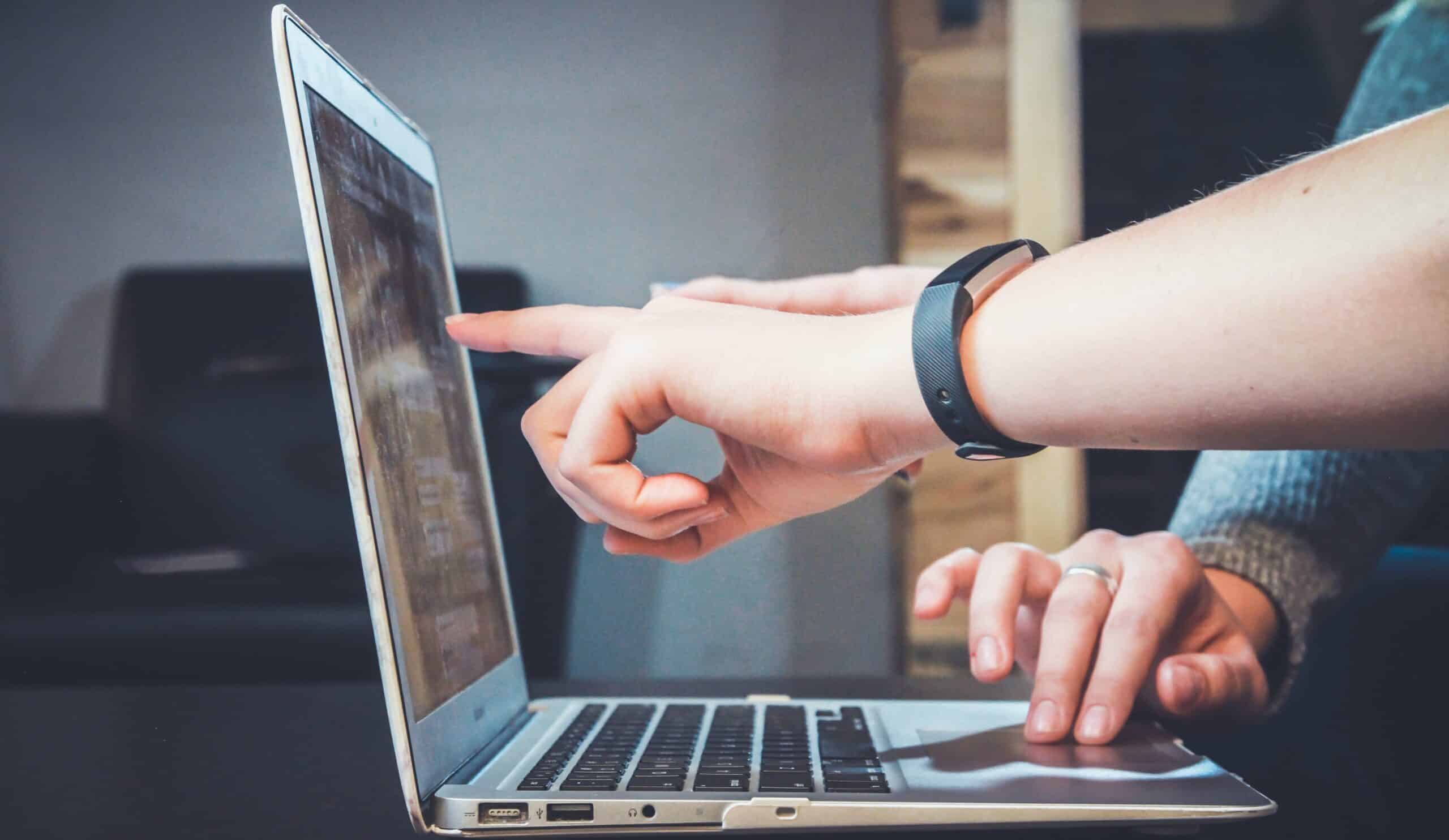 A close-up of hand on a laptop.